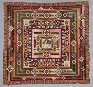 A patchwork quilt made in India or England 1855–1880, using thousands of red, yellow, white, black, and blue 1-inch squares of wool broadcloth from military uniforms. Some are arranged as stars, and there are four quilt patches with detailed beading of British crowns, Prince of Wales feathers, and the colour standards of the 37th Regiment of Foot. The Annette Gero Collection.